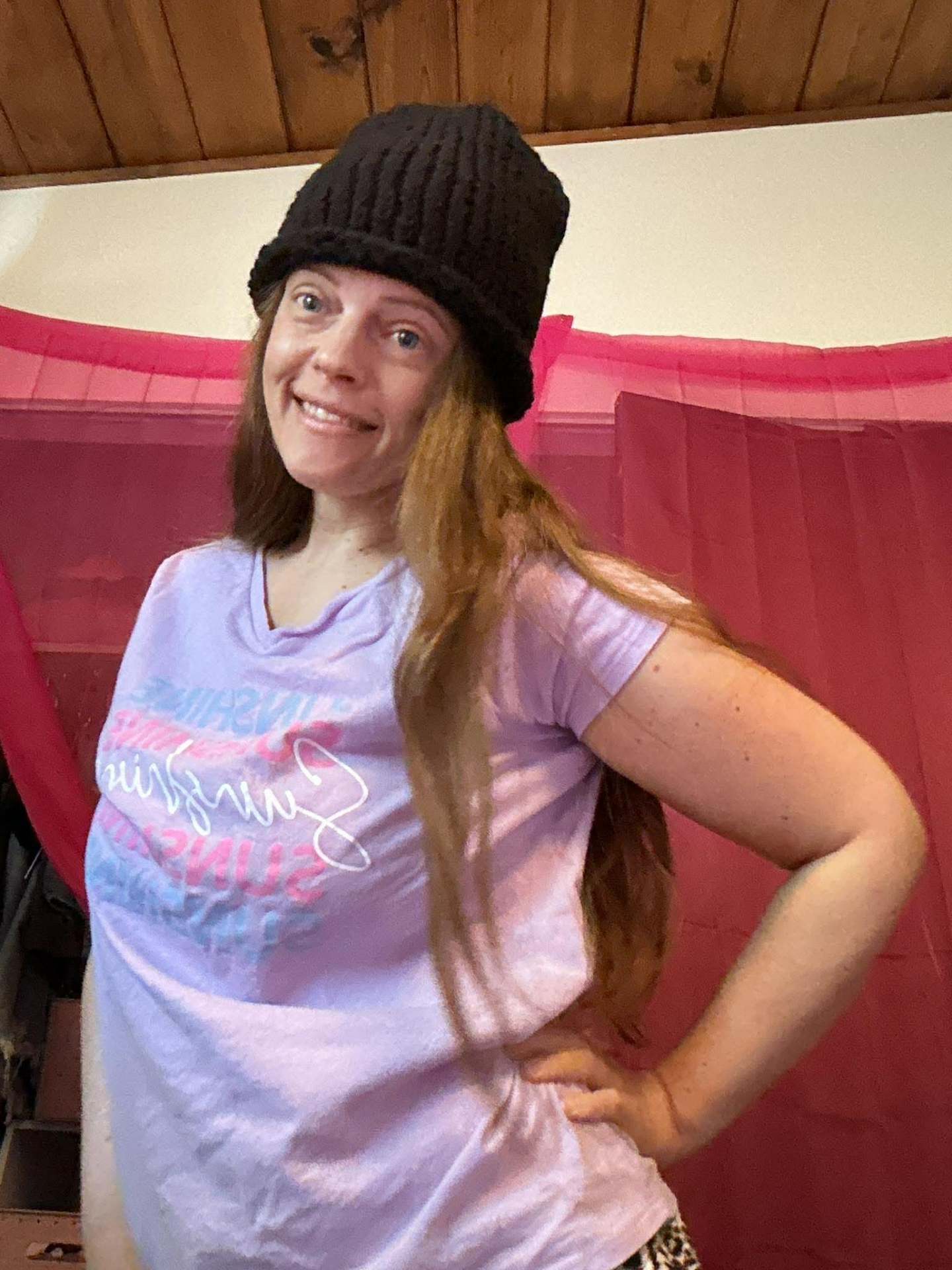 Kailye modeling a hand-knit black beanie